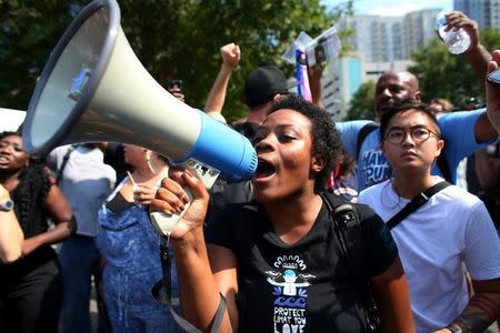 A demonstrator yells into a megaphone outside the football stadium as the NFL's Carolina Panthers host the Minnesota Vikings protesting of the police shooting of Keith Scott in Charlotte, North Carolina, U.S., September 25, 2016. REUTERS/Mike Blake