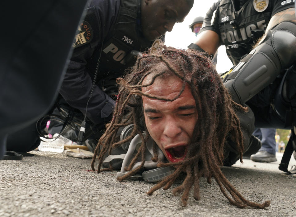 FILE - Louisville police detain a man after a group marched in protest over a lack of charges against Louisville police in Breonna Taylor's death, Wednesday, Sept. 23, 2020, in Louisville, Ky. Recent revelations about the search warrant that led to Breonna Taylor’s death have reopened old wounds in Louisville’s Black community and disrupted the city’s efforts to restore trust in the police department.(AP Photo/John Minchillo, File)