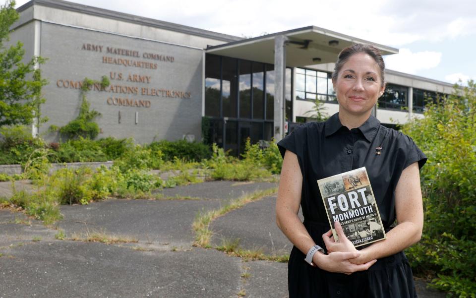 Melissa Ziobro was the last historian at Fort Monmouth before the Army post closed and moved to Maryland. She holds her new book Monday, June 10, 2024, "Fort Monmouth: The U.S. Army's House of Magic," outside the building where she once worked at the post.