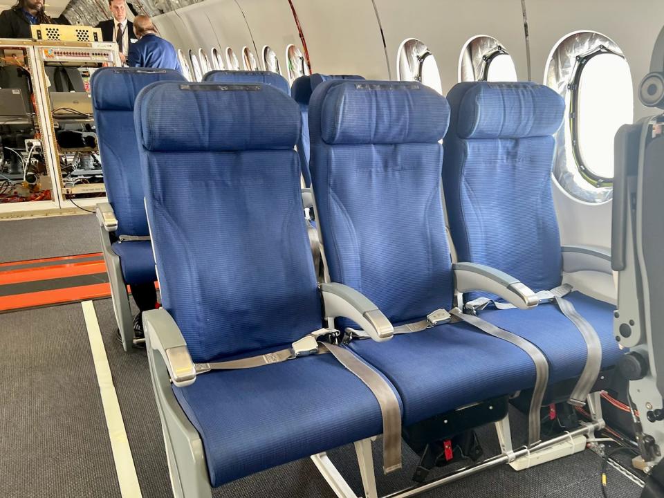 Rows of blue passenger seats on the 777X.