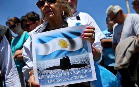 A woman holds a placard with a message that reads in Spanish: "We are with you, brave ones of the ARA San Juan,"  - Credit:  Esteban Felix/AP