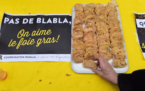 A woman takes a foie gras toast during a pro-foie gras demonstration by activists from the farmers' union "Coordination rurale" on November 16, 2017 in Agen, southwestern France.  - Credit:  NICOLAS TUCAT/AFP