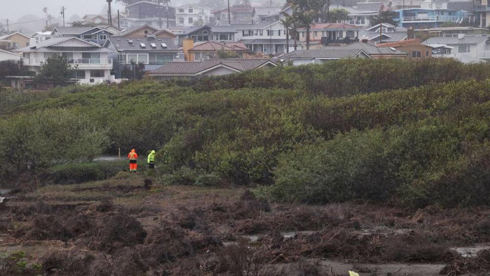 A work crew looks at exposed gas main in Old Creek near Studio Drive in Cayucos on Tuesday, March 14, 2023.