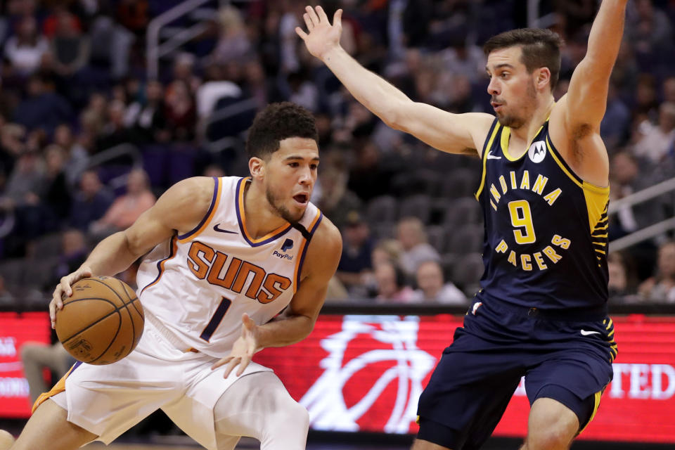 Phoenix Suns guard Devin Booker (1) drives as Indiana Pacers guard T.J. McConnell (9) defends during the second half of an NBA basketball game, Wednesday, Jan. 22, 2020, in Phoenix. (AP Photo/Matt York)