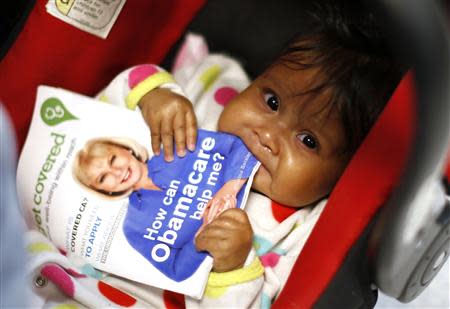 Six-month-old Hazel Garcia chews a pamphlet at a health insurance enrollment event in Cudahy, California March 27, 2014. REUTERS/Lucy Nicholson
