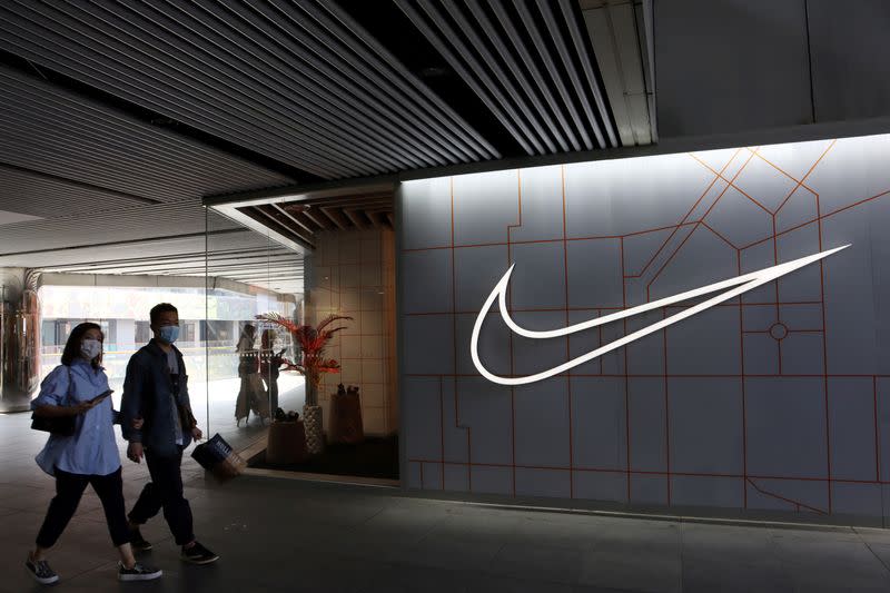 FILE PHOTO: People walk past a Nike Inc store at a shopping complex in Beijing