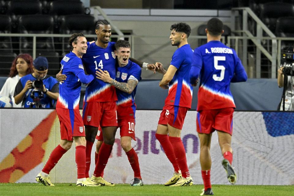 Mar 21, 2024; Arlington, Texas, USA; United States midfielder Haji Wright (14) and forward Josh Sargent (11) and United States forward Brenden Aaronson (11) and forward Christian Pulisic (10) and forward Ricardo Pepi (9) and defender Antonee Robinson (5) celebrate after Wright scores the game winning goal against Jamaica during extra time at AT&T Stadium. Mandatory Credit: Jerome Miron-USA TODAY Sports