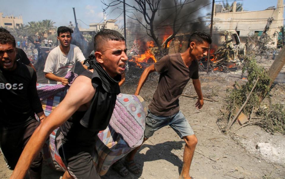 People deal with the aftermath of an Israeli strike on a camp in the Al-Mawasi area of Khan Younis