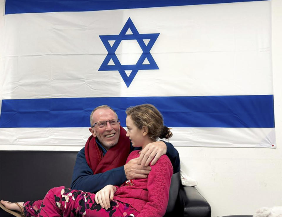 In this photo provided by the Israeli Army, Emily Hand, a released hostage, reunites with her father Sunday, Nov. 26, 2023, in Israel. The tense cease-fire between Israel and Hamas appeared to be back on track after the release of a second group of militant-held hostages and Palestinian prisoners. (The Israeli Army via AP)