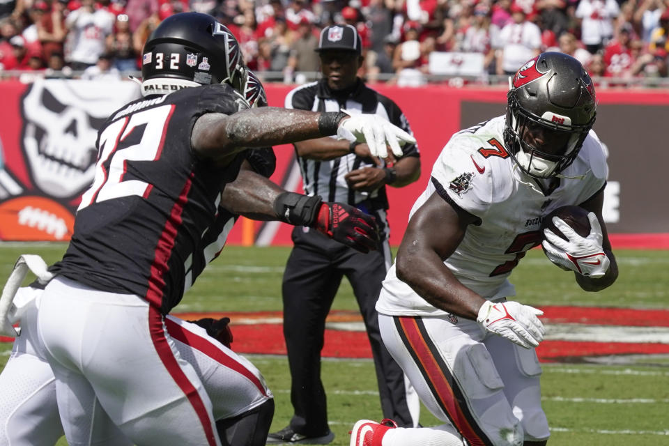 Tampa Bay Buccaneers running back Leonard Fournette (7) runs as Atlanta Falcons safety Jaylinn Hawkins (32) defends during the first half of an NFL football game Sunday, Oct. 9, 2022, in Tampa, Fla. (AP Photo/Chris O'Meara)