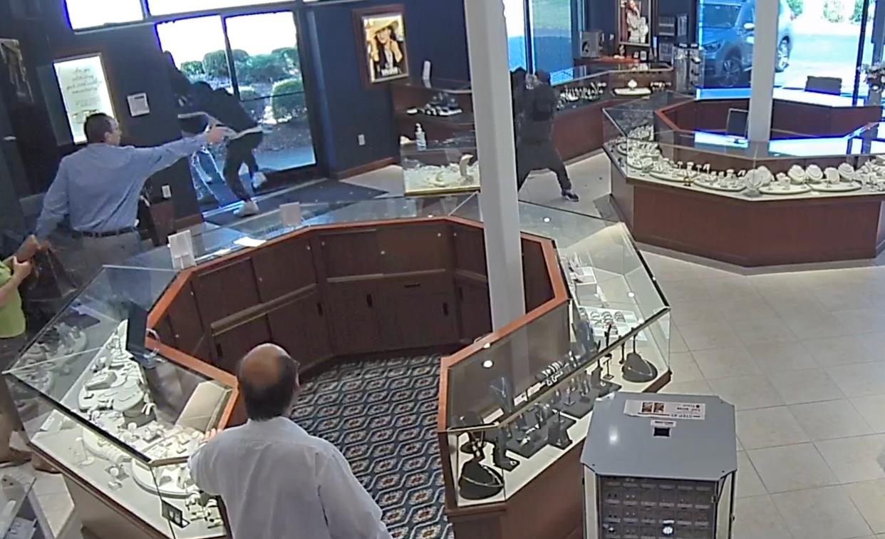 Store owner Michael Hennes is seen running off three suspects who attempted a smash and grab at Morris Jewelers Wednesday afternoon.