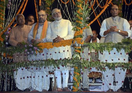 Hindu nationalist Narendra Modi (C), India's prime minister-elect from the Bharatiya Janata Party (BJP), watches a ritual known as "Aarti" during evening prayers on the banks of the river Ganges at Varanasi, in the northern Indian state of Uttar Pradesh, in this May 17, 2014 file photo. REUTERS/Pawan Kumar/Files
