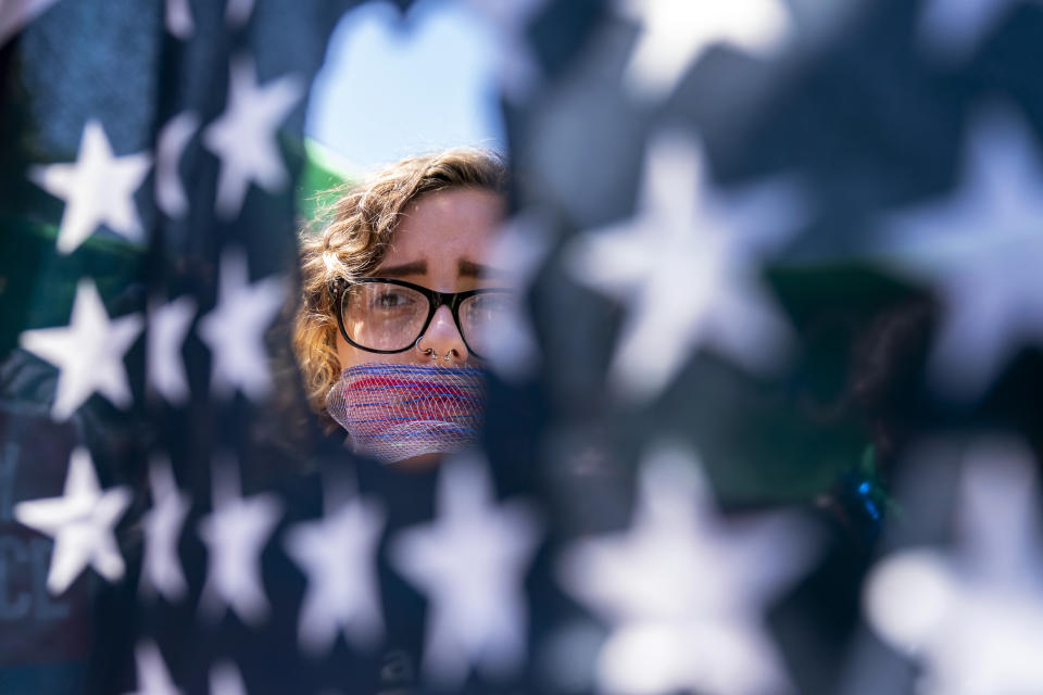 FILE - Emma Rousseau, of Oakland, N.J., her mouth bound with a red, white and blue netting, attends a rally on the Fourth of July to protest for abortion rights, at Lafayette Park in front of the White House in Washington, Monday, July 4, 2022. (AP Photo/Andrew Harnik, File)