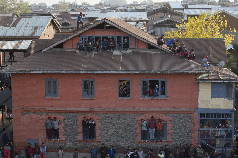 In this Wednesday, Oct. 17, 2018, file photo, Kashmiri Muslims watch the funeral of Mehraj-Ud-Din Bangroo, a rebel commander in Srinagar, India. Anti-India protests and clashes erupted in the main city in disputed Kashmir on Wednesday after a gun battle between militants and government forces killed at least two suspected rebels, a civilian and a counterinsurgency police official, residents and police said. (AP Photo/Dar Yasin, File)