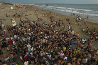 Teenagers gather late afternoon at the beach in Pinamar, Buenos Aires province, Argentina, Saturday, Jan. 15, 2022. Amid a rebound in infections by the new Omicron variant of COVID 19, thousands of vacationers in Argentina fill the beaches in one of the hottest summers in recent years. (AP Photo/Rodrigo Abd)