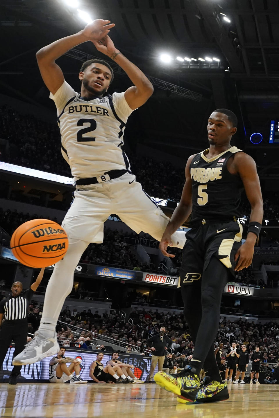 Butler guard Aaron Thompson (2) loses the ball out of bounds ahead of Purdue guard Brandon Newman (5) during the second half of an NCAA college basketball game, Saturday, Dec. 18, 2021, in Indianapolis. (AP Photo/AJ Mast)