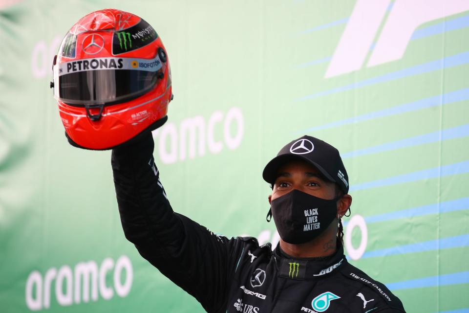 Lewis Hamilton celebrates winning the Eifel Grand Prix after being presented with Michael Schumacher’s helmet (Getty)