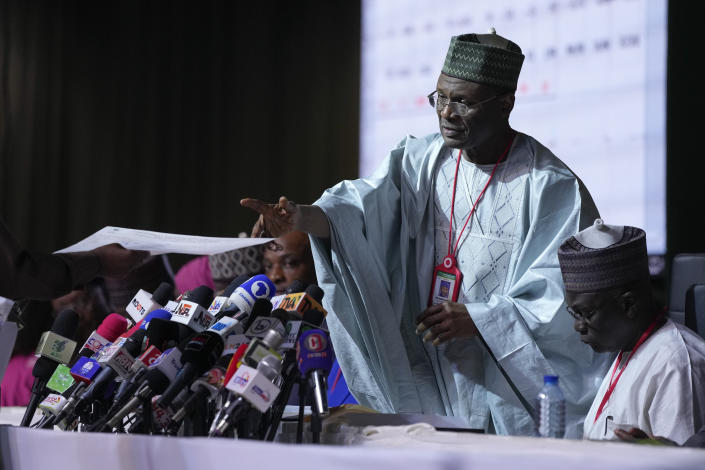 Mahmood Yakubu, chairman of the Independent National Electoral Commission (INEC), receives a document as results for individual states are read out at the National Collation Centre in Abuja, Nigeria, Wednesday, March 1, 2023. Tensions rose in Nigeria Tuesday as the main opposition parties demanded a revote for the country's presidential election, where the latest results show an early lead for the ruling party. (AP Photo/Ben Curtis)