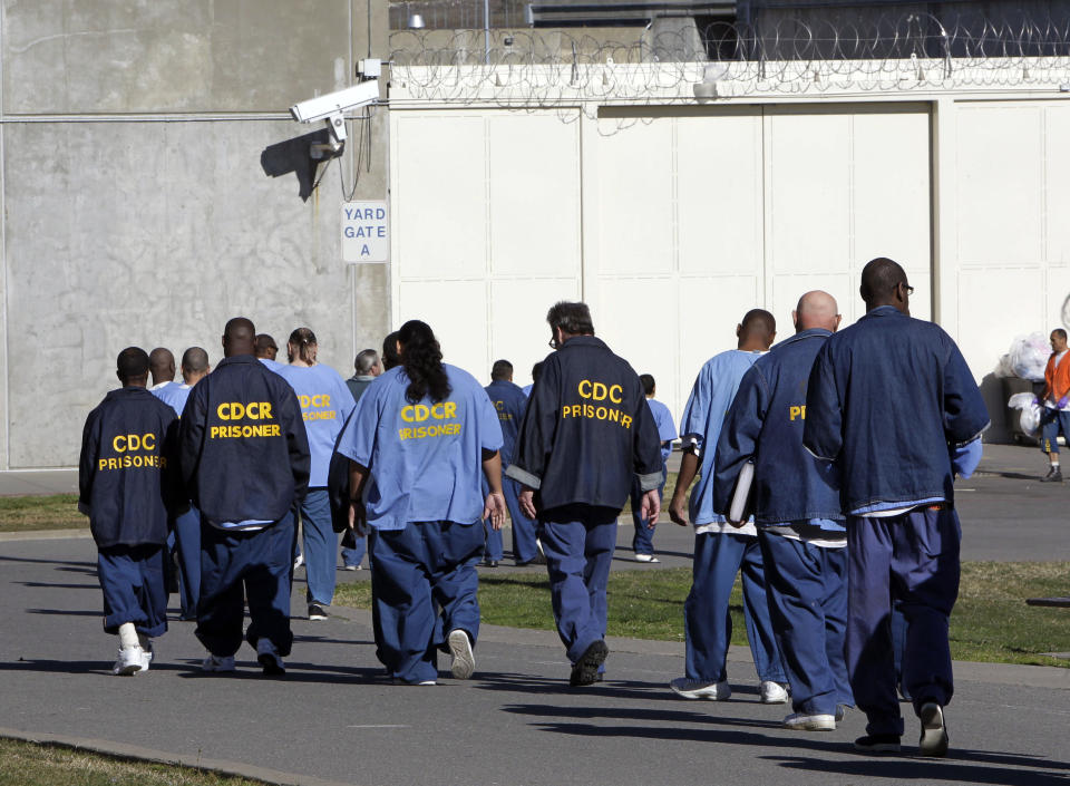 FILE - In this Feb. 26, 2013, file photo, inmates walk through the exercise yard at California State Prison Sacramento, near Folsom, Calif. California arrest rates have dropped nearly 60 percent since 1989, yet blacks are three times more likely to be arrested than whites, according to a report released by the Public Institute of California, Monday Dec. 3, 2018. (AP Photo/Rich Pedroncelli, File)