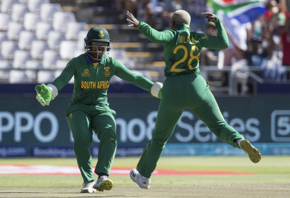 South Africa's Sinalo Jafta, left, celebrates taking the wicket of Australia's Grace Harris with teammate and bowler Nonkululeko Mlaba, during the Women's T20 World Cup semi final cricket match between South Africa and Australia, in Cape Town, South Africa, Sunday Feb. 26, 2023. (AP Photo/Halden Krog)