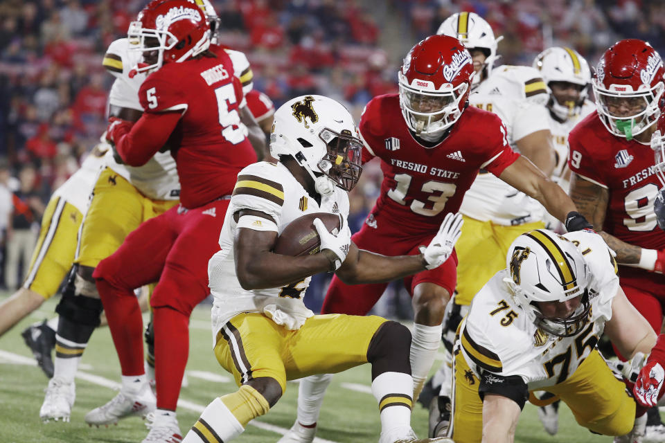 Wyoming running back Titus Swen tries to get past Fresno State defensive back Justin Houston during the first half of an NCAA college football game in Fresno, Calif., Friday, Nov. 25, 2022. (AP Photo/Gary Kazanjian)