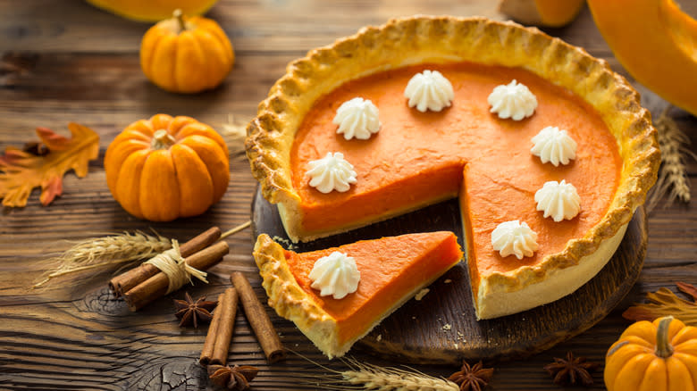 Sliced pumpkin pie on wood