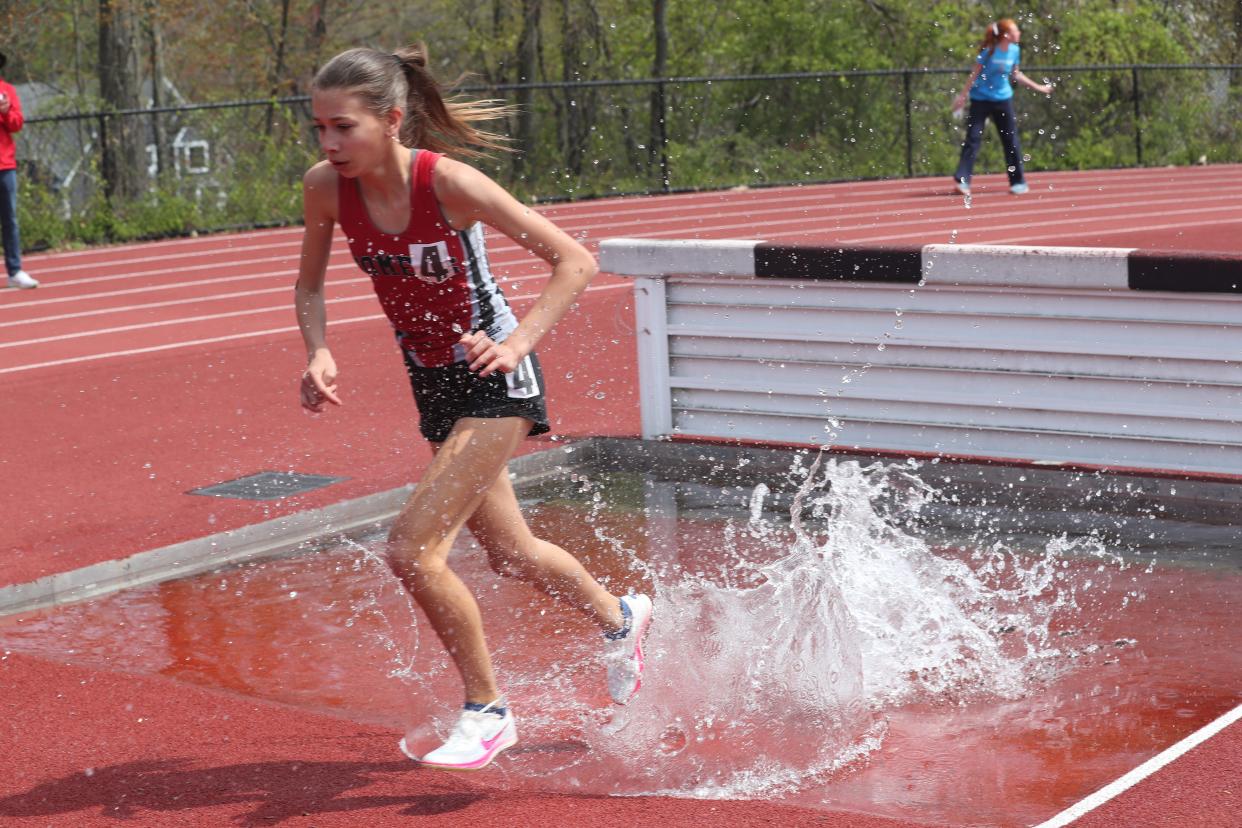 Somers' Julia Duzysnki emeges from the water jump puit en route to winning the Gold Rush Invitational girls 2,000-meter steeplechase April 27, 2024 at Clarkstown South High School.
