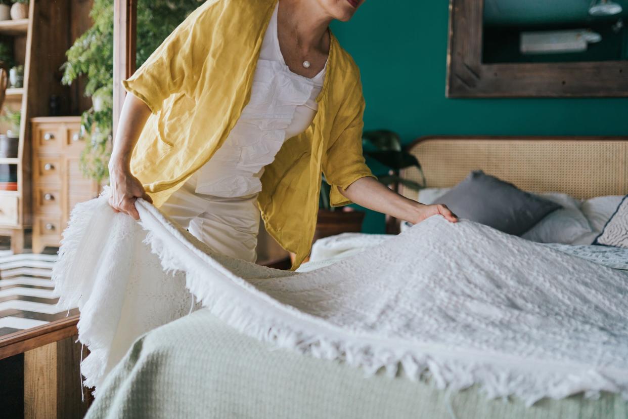 Cropped shot of senior Asian woman doing her morning routine, making up her bed at home. Let's get the day started