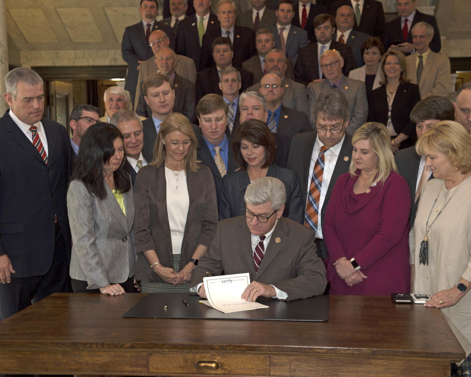 Surrounded by Mississippi legislators, Gov. Phil Bryant signs into law a bill banning abortions after a heartbeat is detected. The new legislation is among the most restrictive in the country. Thursday, March 21, 2019.