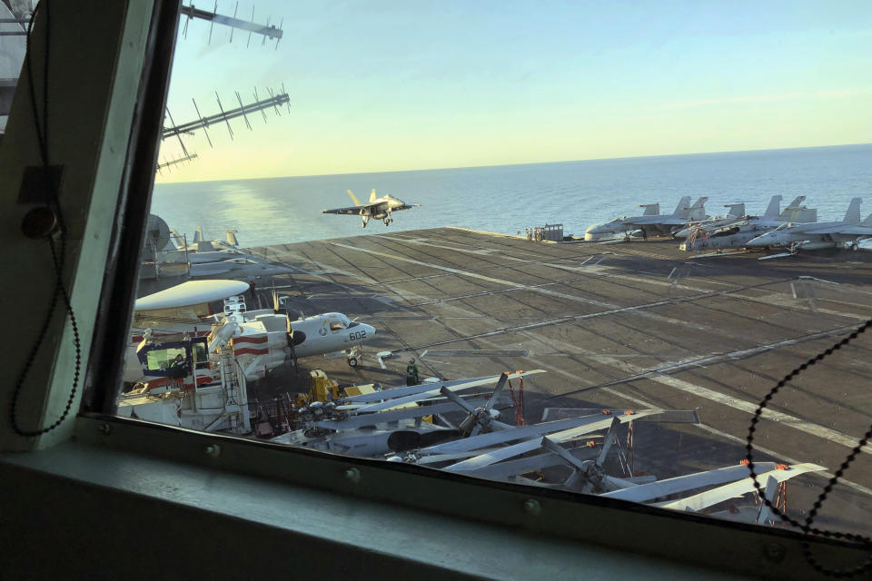 FILE - The view as Marine Gen. Frank McKenzie, top U.S. commander for the Middle East, watches from the bridge as an F/A 18 fighter jet lands on the USS Harry S. Truman, Feb. 1, 2020. Defense Secretary Lloyd Austin has ordered a U.S. Navy aircraft carrier strike group to stay in the Mediterranean Sea region rather than move on to the Middle East, amid worries about the buildup of thousands of Russian troops near the Ukraine border. A defense official said Tuesday, Dec. 28, 2021, that the change in the schedule of the USS Harry S. Truman, and the five American warships accompanying it, reflects the need for a persistent presence in Europe. (AP Photo/Lolita Baldor, File)