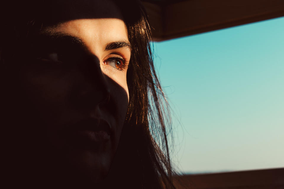 woman's face with shadows everywhere except her eye