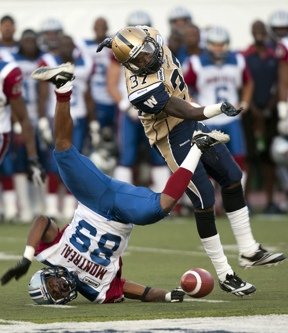 Montreal Alouettes receiver Travon Patterson, left, is tackled by Winnipeg Blue Bombers Demond Washington during first quarter Canadian Football League pre-season action Thursday, June 14, 2012 in Montreal. THE CANADIAN PRESS/Ryan Remiorz