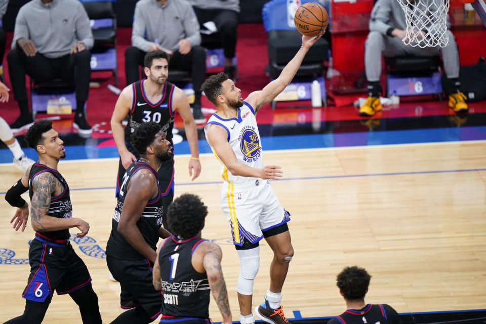 Golden State Warriors' Stephen Curry, right, goes for a shot during the first half of an NBA basketball game against the Philadelphia 76ers, Monday, April 19, 2021, in Philadelphia. (AP Photo/Matt Slocum)