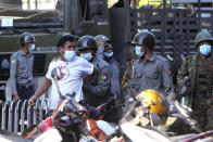 FILE - In this Feb. 15, 2021, file photo, a man is held by police during a crackdown on anti-coup protesters holding a rally in front of the Myanmar Economic Bank in Mandalay, Myanmar. The escalation of violence in Myanmar as authorities crack down on protests against the Feb. 1 coup is adding to pressure for more sanctions against the junta, as countries struggle over how to best confront military leaders inured to global condemnation.(AP Photo/File)