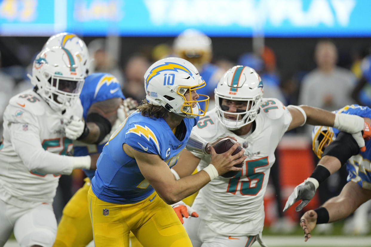 Los Angeles Chargers quarterback Justin Herbert (10) is chased by Miami Dolphins linebacker Jaelan Phillips (15). (AP Photo/Mark J. Terrill)