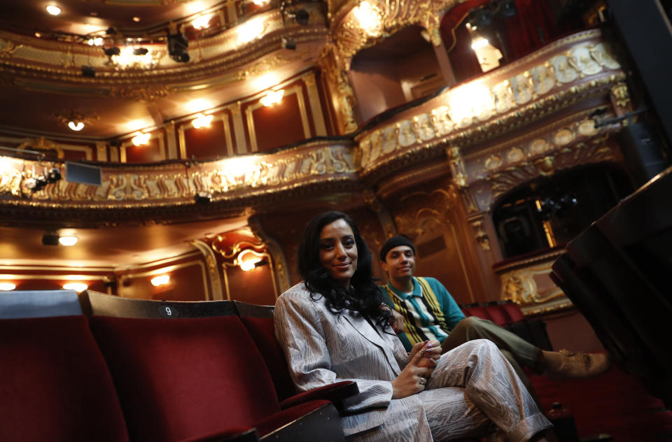 Leading actors of the musical "Everybody's Talking About Jamie', Noah Thomas, right who plays Jamie and Hiba Elichike, who portrays Pritti Pasha, pose for a photo during an interview with the Associated Press in the auditorium of the Apollo Theater where the musical is getting prepared to continue its run in London, Tuesday, April 20, 2021. (AP Photo/Alastair Grant)