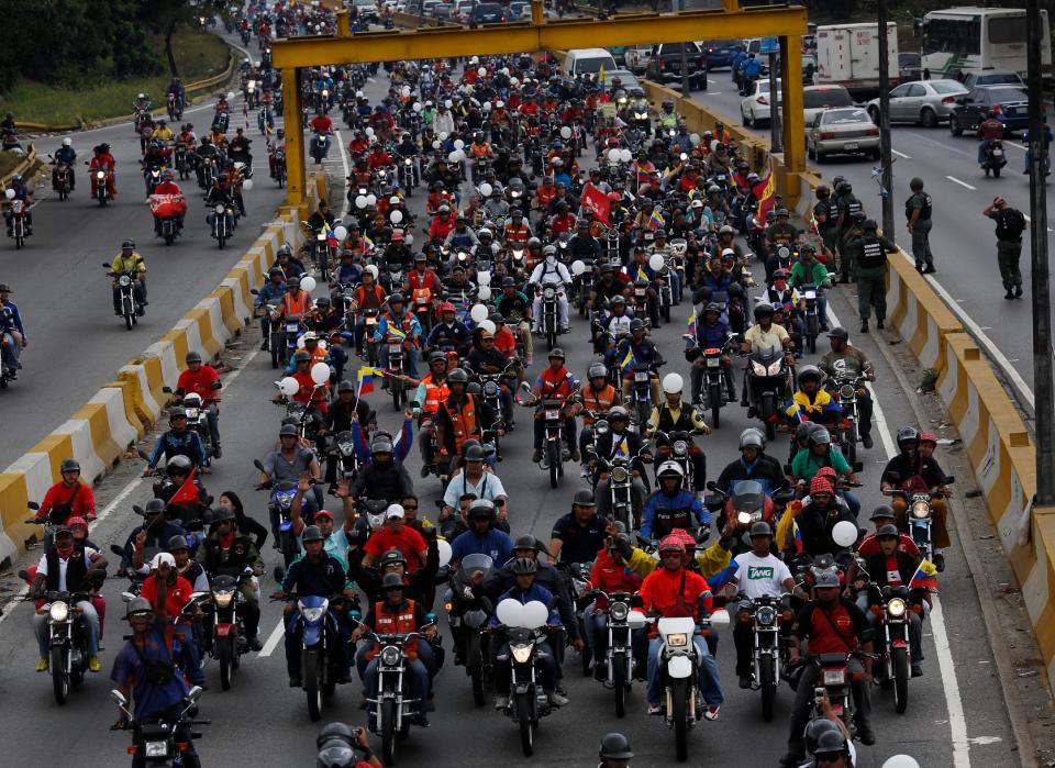 Motociclistas participan de una recorrida a favor del presidente venezolano Nicolás Maduro en Caracas el lunes 24 de febrero de 2014. La capital venezolana amaneció el lunes en medio de nuevas tensiones luego de que decenas de manifestantes bloquearon algunas de las principales avenidas en protesta contra el gobierno, en medio de la crisis política que lleva tres semanas y ha dejado 14 muertos y más de un centenar de heridos. (AP foto/Rodrigo Abd)
