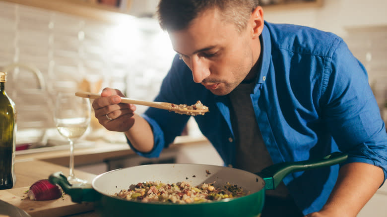 man taste testing risotto