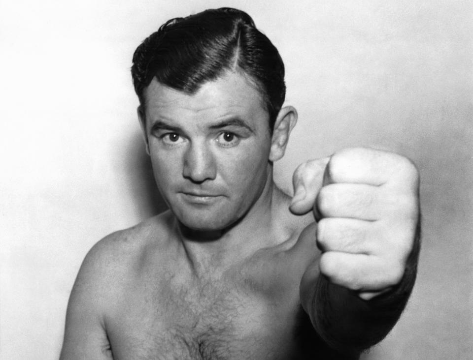 Le boxeur Jimmy Braddock brandit son poing pour indiquer qu'il est de nouveau apte au combat après une blessure à la main le 23 novembre 1936 à New York City, NY. (Photo by KEYSTONE-FRANCE/Gamma-Rapho via Getty Images)