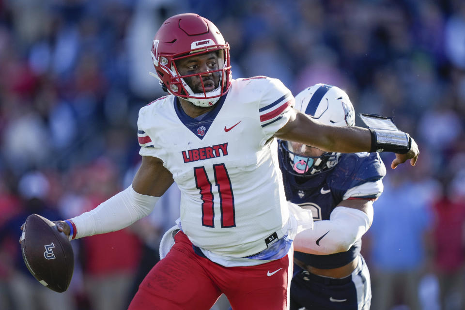 Liberty quarterback Johnathan Bennett (11) scrambles with the ball during the second half of an NCAA college football game against Connecticut in East Hartford, Conn., Saturday, Nov. 12, 2022. (AP Photo/Bryan Woolston)