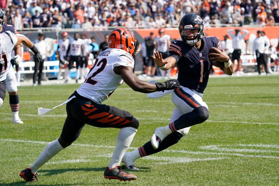 Chicago Bears quarterback Justin Fields (1) prepares to stiff-arm Cincinnati Bengals cornerback Chidobe Awuzie during the second half of an NFL football game Sunday, Sept. 19, 2021, in Chicago.