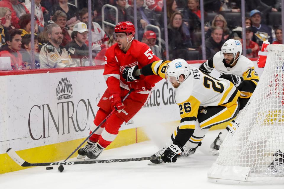 Red Wings left wing David Perron fights for control of the puck with Penguins defenseman Jeff Petry during the second period on Tuesday, March 28, 2023, at Little Caesars Arena.