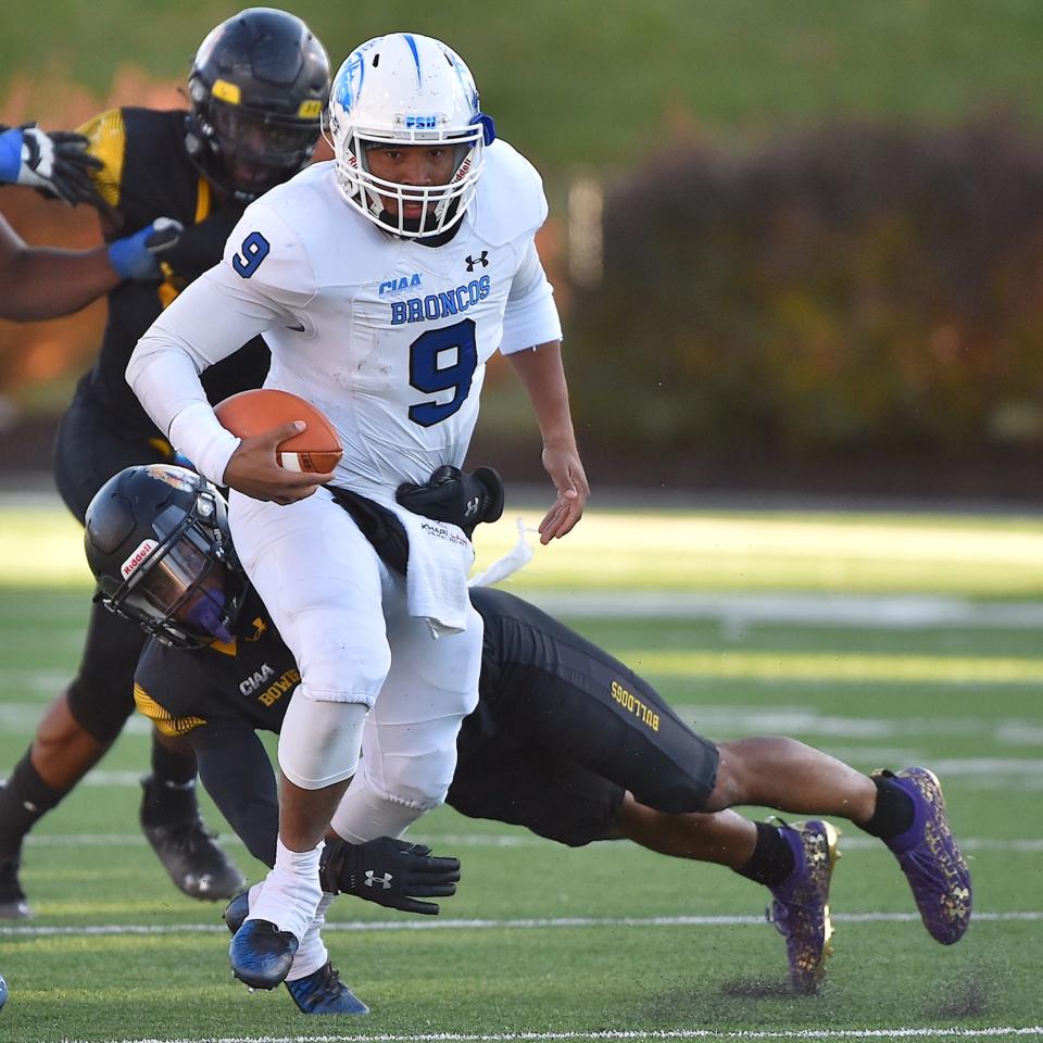 Fayetteville State quarterback K'Hari Lane (9) runs for yardage while grappled by Bowie State's Jordan Carter (4) in the fourth quarter. The Bowie State Bulldogs and the Fayetteville State Broncos met in the 2021 CIAA Football Finals in Salem Virginia on November 13, 2021