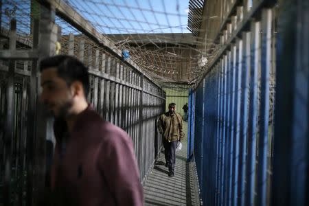 Palestinians working in Israel cross through Israeli Qalandia checkpoint near the West Bank city of Ramallah April 18, 2017. REUTERS/Ammar Awad