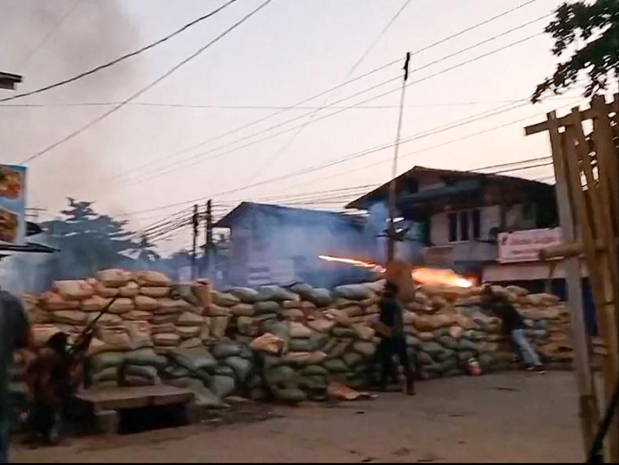 <p>Protesters set off fireworks from behind a barricade during a military crackdown on demonstrations in Bago</p> (AFPTV/AFP via Getty)