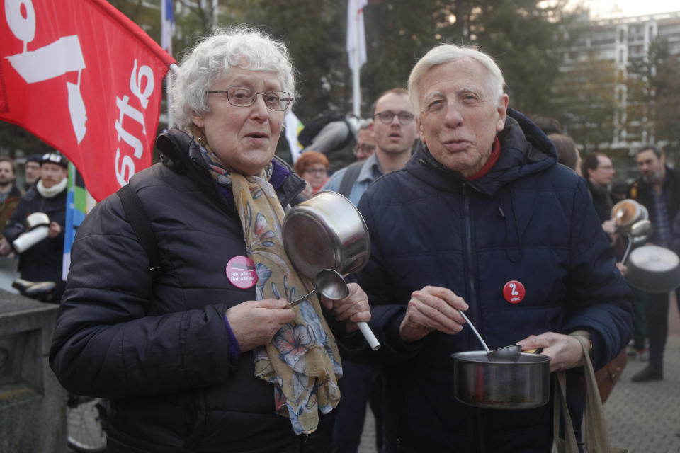 Elderly people bang pots and pans while French President Emmanuel Macron seeks to diffuse tensions in a televised address to the nation, Monday, April 17, 2023 in Lille, northern France. French President Emmanuel Macron, who just enacted protest-igniting pension changes, is expected to provide details about his domestic policies in the coming months. (AP Photo/Michel Spingler)