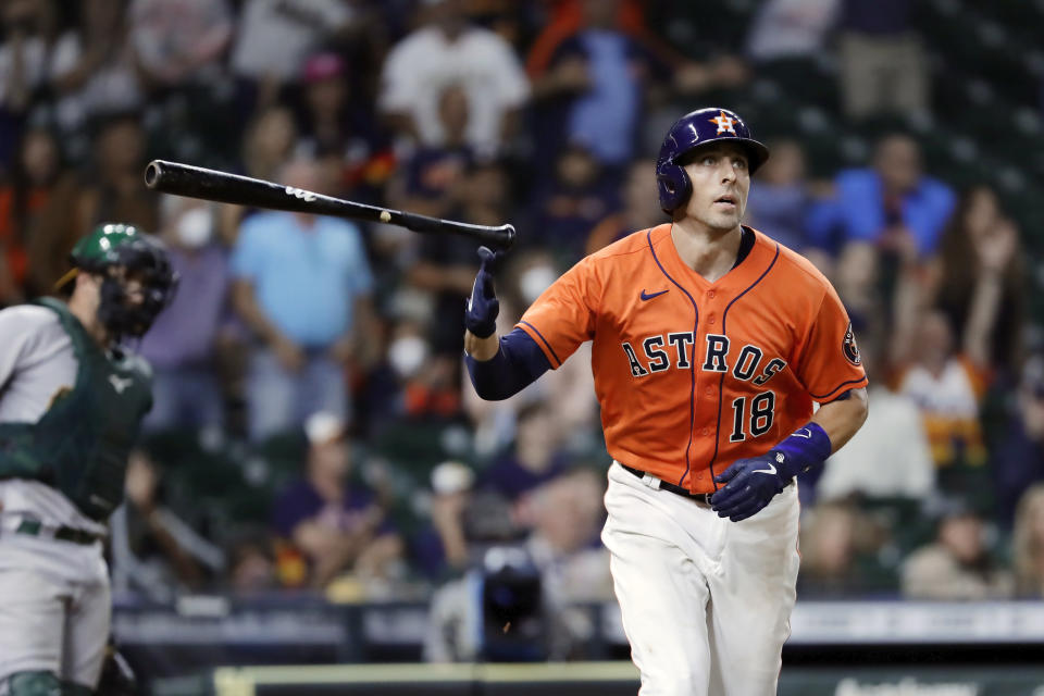 Houston Astros' Jason Castro (18) flips his bat as he watches his three run home run in front of Oakland Athletics catcher Yan Gomes, left, during the eighth inning of a baseball game Friday, Oct. 1, 2021, in Houston. (AP Photo/Michael Wyke)