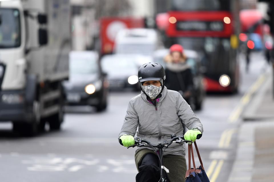 A cyclist wears a helmet and a mask as they travel by bicycle along a road in London on March 2, 2020. (Photo by DANIEL LEAL-OLIVAS / AFP) (Photo by DANIEL LEAL-OLIVAS/AFP via Getty Images)