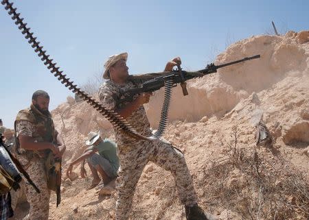 A fighter of Libyan forces allied with the U.N.-backed government fires a weapon during a battle with IS fighters in Sirte, Libya, July 21, 2016. REUTERS/Goran Tomasevic