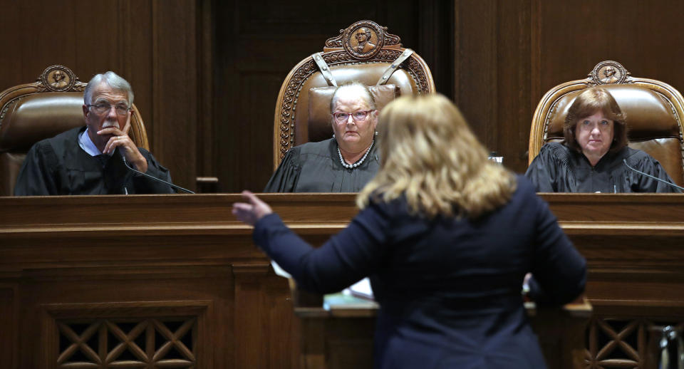 Justice Charles W. Johnson, left, Chief Justice Mary E. Fairhurst and Justice Barbara A. Madsen look on as Michele Earl-Hubbard, attorney for the media coalition, speaks during a hearing before the Washington Supreme Court Tuesday, June 11, 2019, in Olympia, Wash. The court heard oral arguments in the case that will determine whether state lawmakers are subject to the same disclosure rules that apply to other elected officials under the voter-approved Public Records Act. The hearing before the high court was an appeal of a case that was sparked by a September 2017 lawsuit filed by a media coalition, led by The Associated Press. (AP Photo/Elaine Thompson)